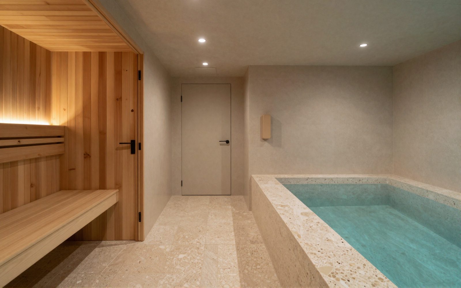 A sauna door beside a cold plunge